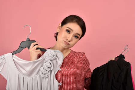 Asian woman choosing cloth in studio shot, What to wear selection for proper dressing. Fashion...