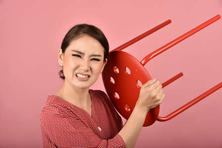 Angry asian woman, Screaming girl with furious aggressive hand gesture on pink background, Face expression and human emotion.の写真素材