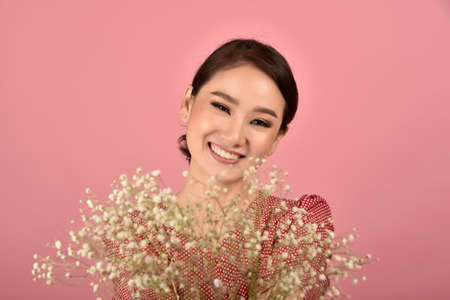 Asian woman relaxing on pink background, Portrait of happy smiling middle age woman in casual clothes looking at the camera.の写真素材