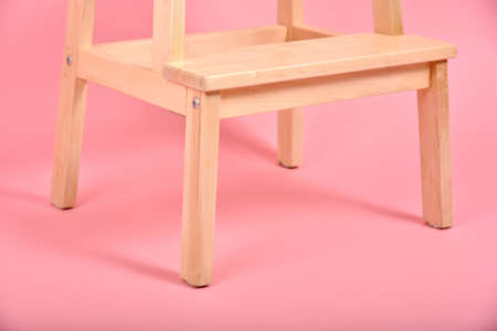 Minimal interior style, Detail of wood chair leg on pastel pink background, Minimalism furniture.