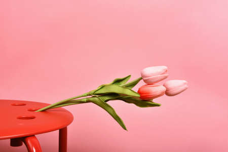 Tulip flowers bouquet for celebration on pink background. Artificial tulips arrangement.