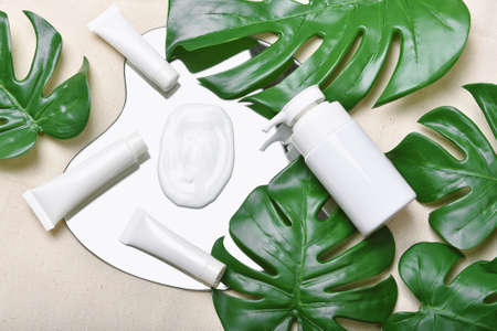 Natural skincare beauty product with cream texture, Cosmetic bottle containers packaging with green nature leaves, Blank label for organic spa branding mock-up,Herbal healthy skin care.の写真素材
