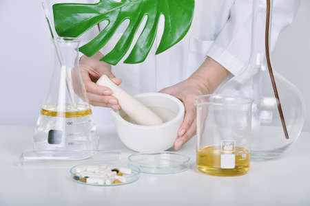 Alternative herbal medicine, Mortar with healing botanical herbs, Natural organic botany and scientific glassware, Natural skin care beauty products, Research and development concept.の写真素材