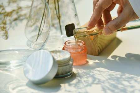 Scientist mixing natural skin care beauty products, Organic botany extraction and scientific laboratory glassware, Blank label cosmetic container for branding mock-up.の写真素材