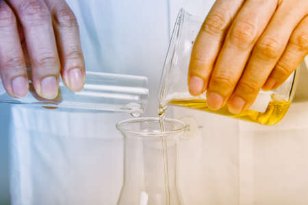 Chemical reagent pouring and mixing, Laboratory and science experiments, Oil formulating the chemical for medical research.の写真素材