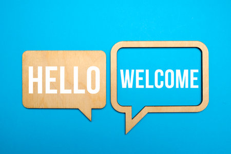 Hello and welcome symbol. Concept words Hello and welcome on wooden speech bubbles. Business hello and welcome concept. Copy space.の写真素材
