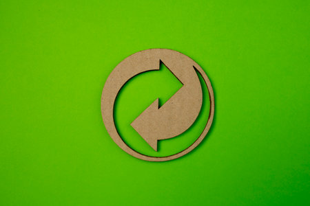 Recycling symbol for cardboard and paper packaging on green paper background with copy space.の写真素材
