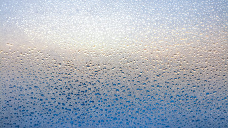 Abstract background of condensation water droplets on glass with smooth blue gradient tones. Minimal...