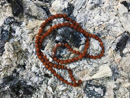 Rosary prayer beads on the ash cinder background. Rudraksha. Mala. Mantra.