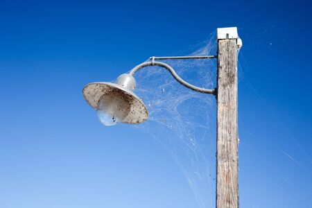 old latern in front of blus sky with spiderwebsの写真素材