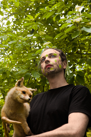 man with facepaint has a fox arm in theの写真素材