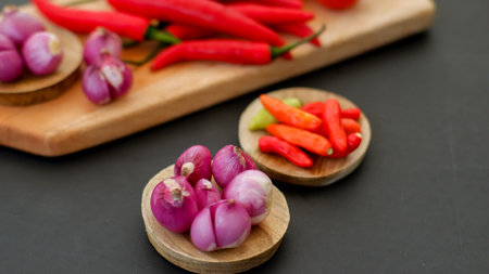 Indonesian chili sauce ingredients isolated on black background. Red chili, shallot, hillbilly tomato, red hot chili pepper.の写真素材