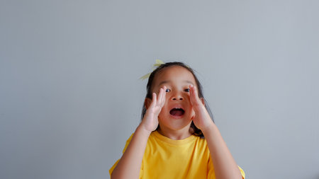 portrait the shouting or yelling child on a yellow background. emotions concept .の写真素材