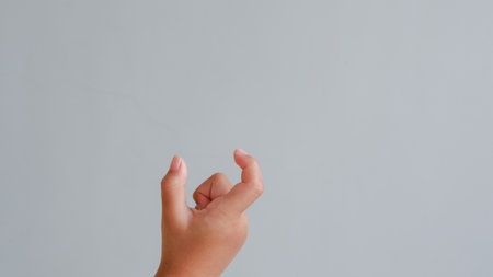 Hand of a child on a gray background. The hand of a child holding something.の写真素材