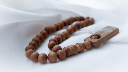 Islamic wooden prayer beads on a white fabric. Design concepts on the theme of Ramadan or other Islamic religious events. Ramadan greeting card background.の写真素材