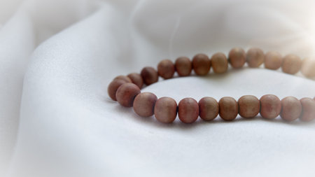 Islamic wooden prayer beads on a white fabric. Design concepts on the theme of Ramadan or other Islamic religious events. Ramadan greeting card background.の写真素材