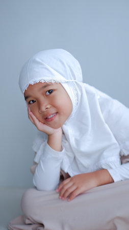 moslem young girl wearing hijab with cute and beautiful pose over gray background.の写真素材