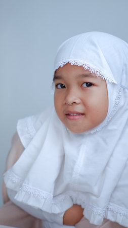 moslem young girl wearing hijab with cute and beautiful pose over gray background.の写真素材