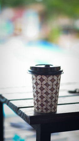 A cup of coffee in batik patterned papercup. Coffee take away at coffee shop.の写真素材