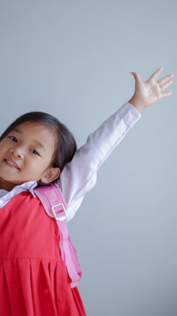 Asian student wearing school uniform and going to school, say hi or waving goodbye to friends at school. back to school concept.の写真素材