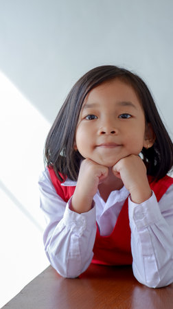 cute asian child wearing school uniform, pensively and thinking concept. sweet smiling.の写真素材
