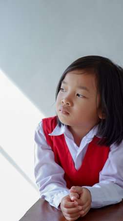 cute asian child wearing school uniform, pensively and thinking concept.の写真素材