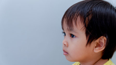 side view of little asian boy with glum face