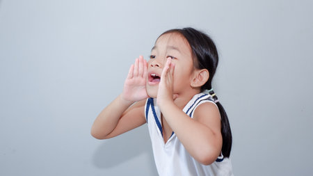 Little asian girl kid wearing casual clothes shouting out loud with hands over mouth