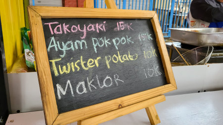 A blackboard with the inscription of a restaurant menu in Thai.