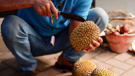 hand of Asian man using knife to open durianの写真素材