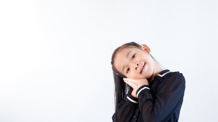Closeup happy cute little Asian girl in black dress smiling over gray backgroundの写真素材
