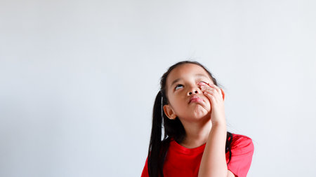 little asian girl tired, lethargic, bored, bad mood concept. studio shot with light color...