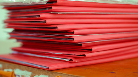 stack of red folders on the tableの写真素材