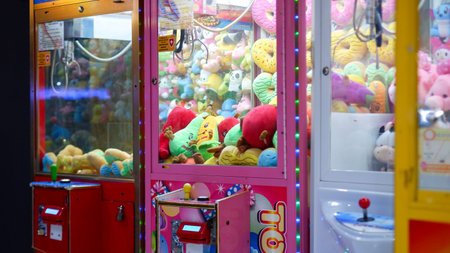 A claw crane game machine at game center. The soft toys sold in coin with many dolls inside.のeditorial素材