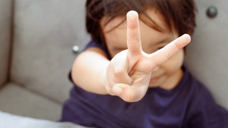 Portrait of child boy showing victory hand signの写真素材