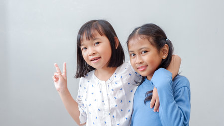 Photo of positive friendship hands palms girl fingers show v-sign have good mood isolated on grey color backgroundの写真素材