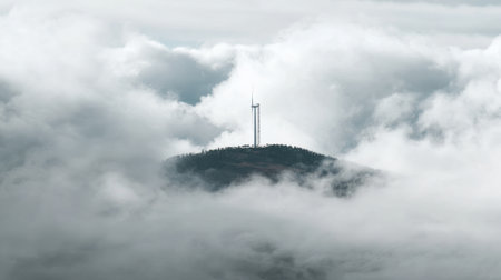 A stunning mountain landscape featuring a tower gracefully rising above a sea of soft clouds, enveloped in a serene and tranquil atmosphere.の素材