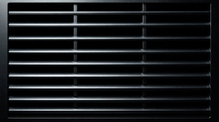 This image showcases a close-up view of a sleek vent cover featuring horizontal slats against a black background, emphasizing modern design and functionality.の素材
