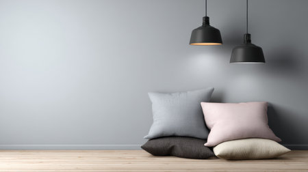 A stylish minimalist interior showcases soft cushions in muted colors against a grey wall, illuminated by elegant pendant lights, evoking a cozy atmosphere.の素材