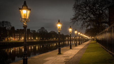 A serene riverside view showcases vintage street lamps casting warm light along a peaceful path, surrounded by trees, reflecting in calm waters.の素材