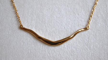 This stunning gold necklace features a wavy design that adds elegance and charm. Perfect for fashion enthusiasts and jewelry promotions.の素材