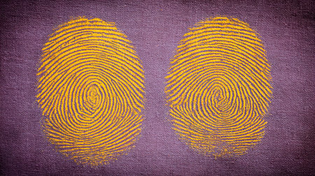 This image showcases two yellow fingerprints on a rich purple fabric background, symbolizing identity, security, and uniqueness in artistic design.の素材