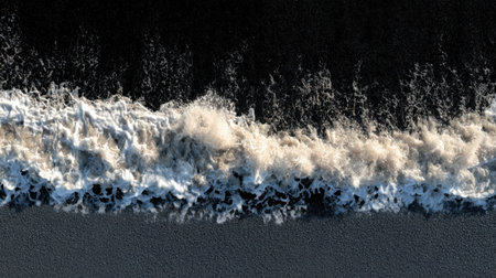 This stunning aerial photograph captures the dynamic movement of waves crashing on the sandy beach. The foamy whitecaps contrast beautifully against the dark ocean depths, creating a captivating landscape of nature's raw power and beauty.の素材