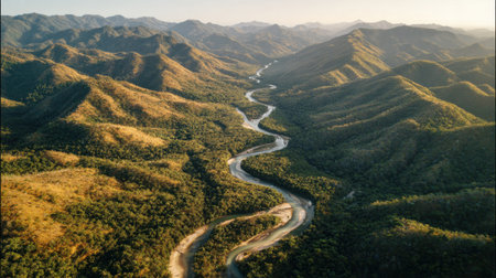 Captivating aerial view of a winding river flowing through lush green mountains under a beautiful sunset. This breathtaking landscape showcases nature's tranquility.の素材