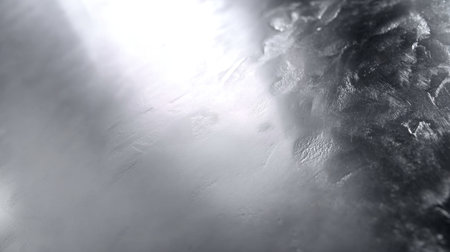 This image features an abstract metallic surface with a silver texture enhanced by soft lighting and gradients, perfect for artistic projects or backgrounds.の素材