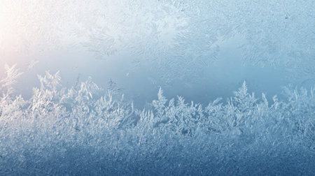 This image features a frosted window showcasing intricate ice patterns in blue and white tones, creating a serene and wintry atmosphere, perfect for winter themes.の素材