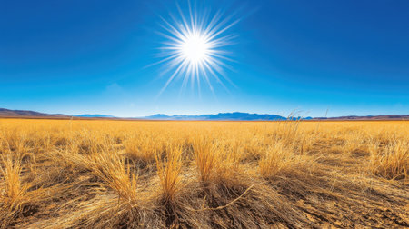A breathtaking view of a golden grassland under a brilliant blue sky filled with sunlight. The distant mountains add depth to the serene landscape, inviting outdoor exploration.の素材