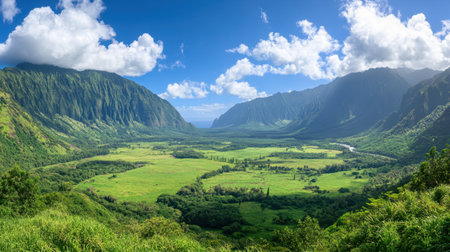 A stunning view of a lush green valley embraced by towering mountains, with a clear blue sky adorned by fluffy clouds, perfect for adventure seekers.の素材