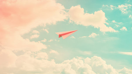 A striking paper airplane glides gracefully through a blue and pink sky, surrounded by fluffy clouds, embodying travel, creativity, and freedom.の素材