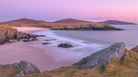 A breathtaking coastal landscape at dusk featuring gentle waves lapping against rugged rocks and vibrant skies, perfect for tranquility and nature appreciation.の素材